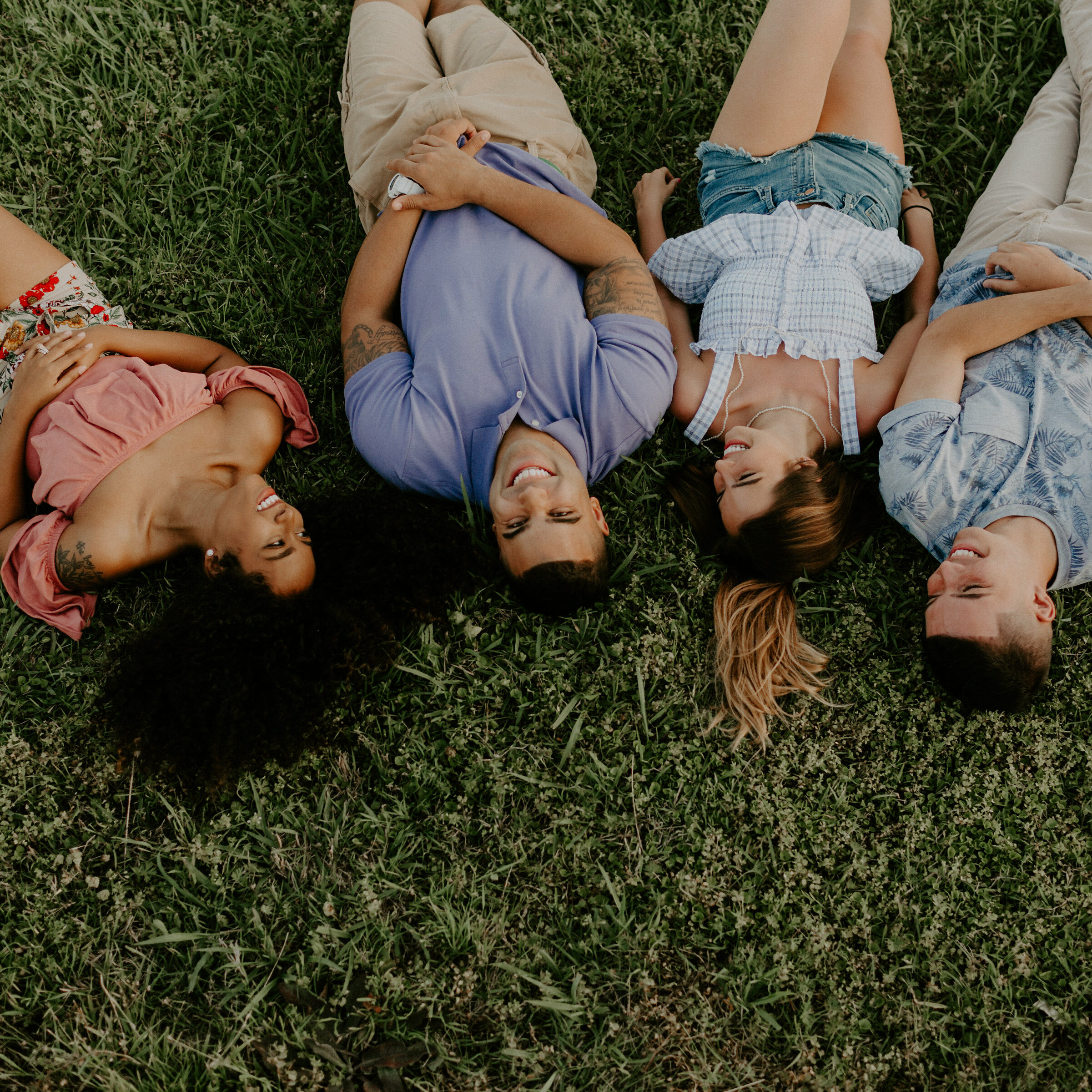 four friends laying in the grass