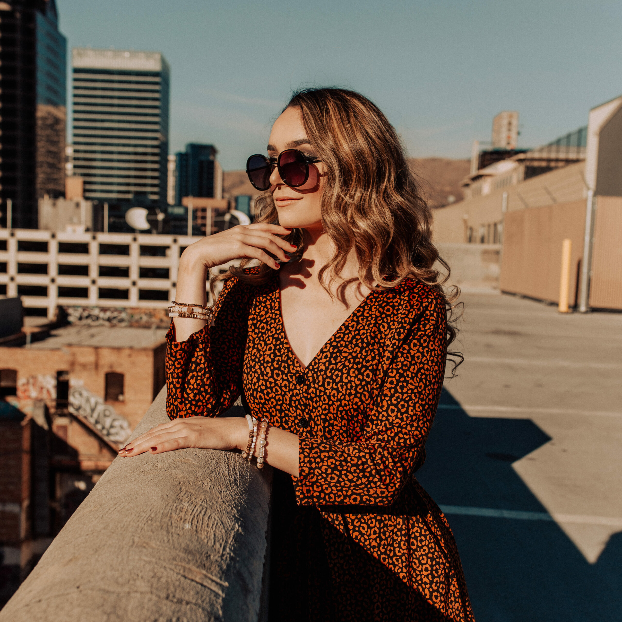 girl leaning on wall on the roof in sunglasses from uptown cheapskate